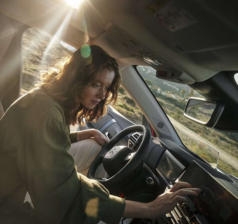 Жінка натискає на сенсорний екран у салоні автомобіля Citroën