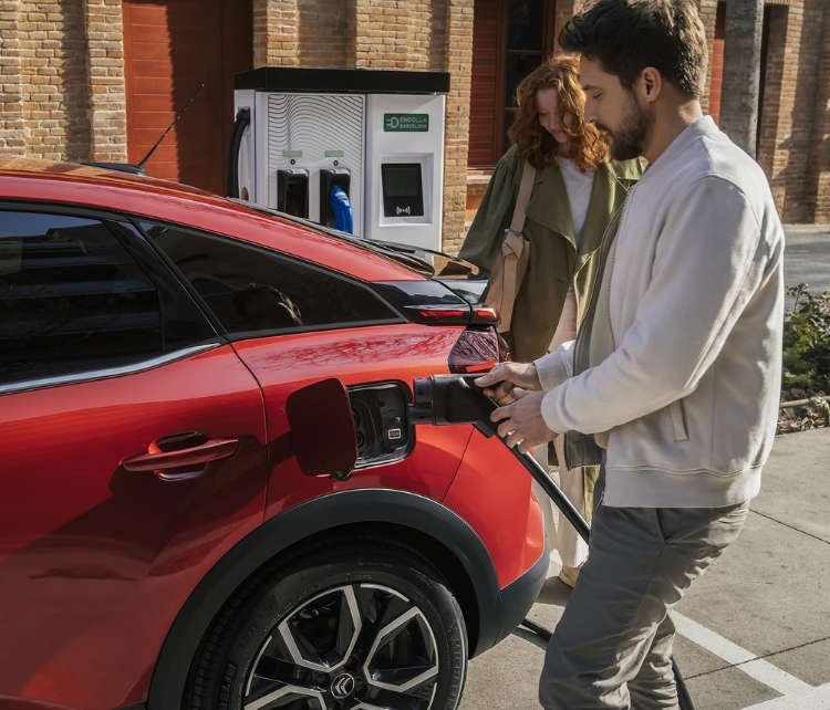 Чоловік вставляє вилку у зарядне гніздо електромобіля Citroën ë-C4